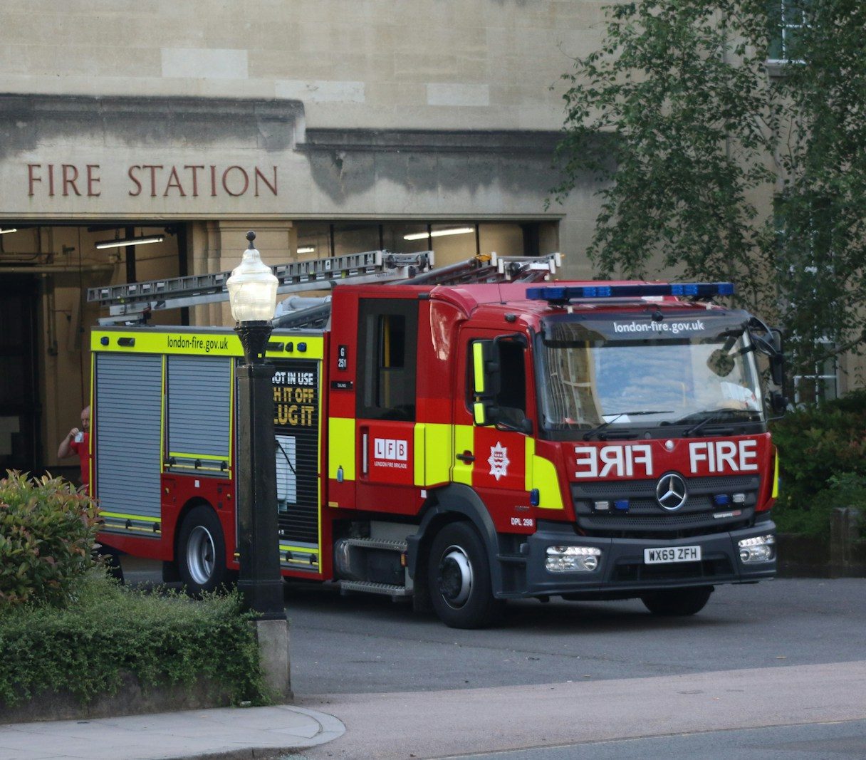 red and yellow fire truck parked near building during daytime